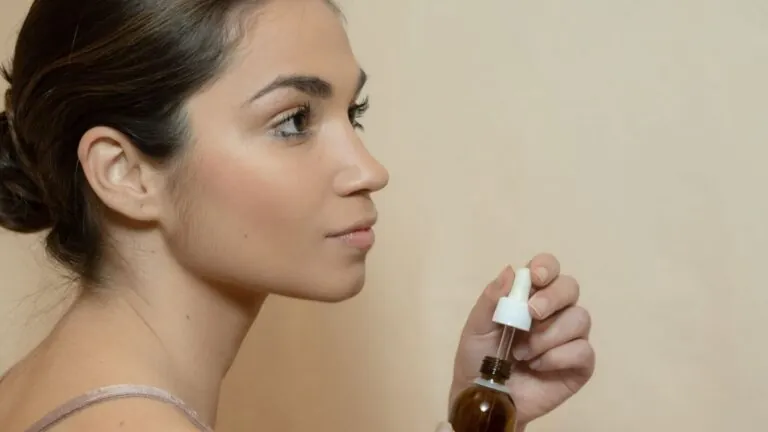 Woman holding a dropper bottle of face oil