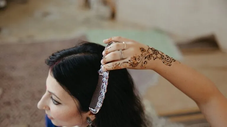 Indian woman with henna-decorated hands touching her long hair
