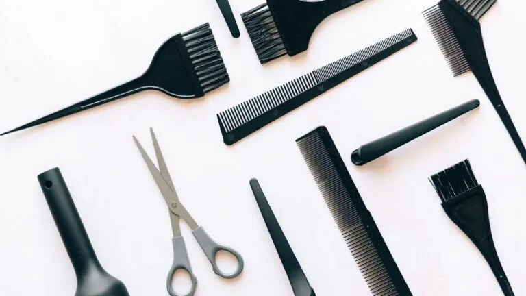 Hair cutting scissors, combs and brushes on white