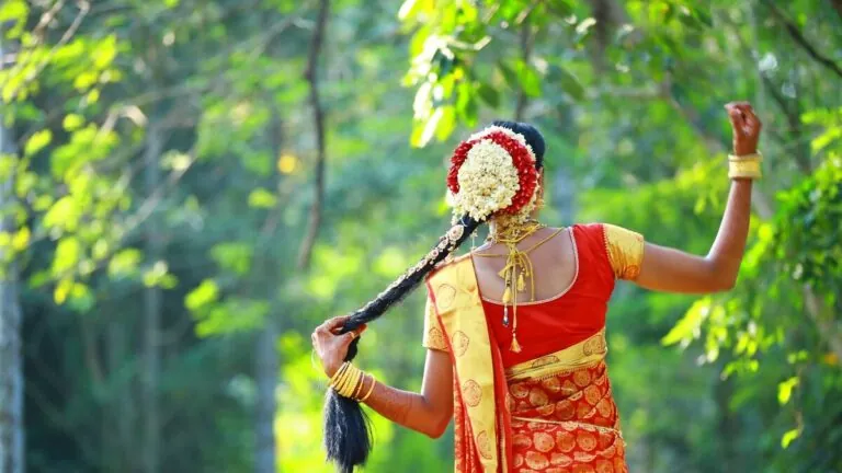 Woman in red saree with flower-decorated long braid