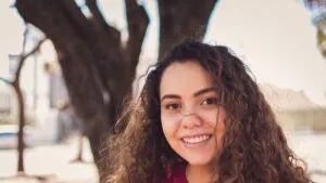 Smiling woman with long curly hair outdoors