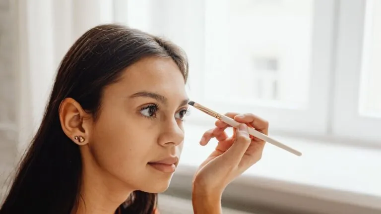 Woman applying eyeshadow with a small makeup brush