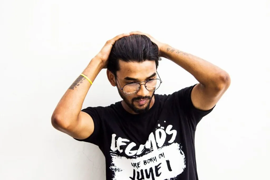 Young Indian man running his hands through styled hair