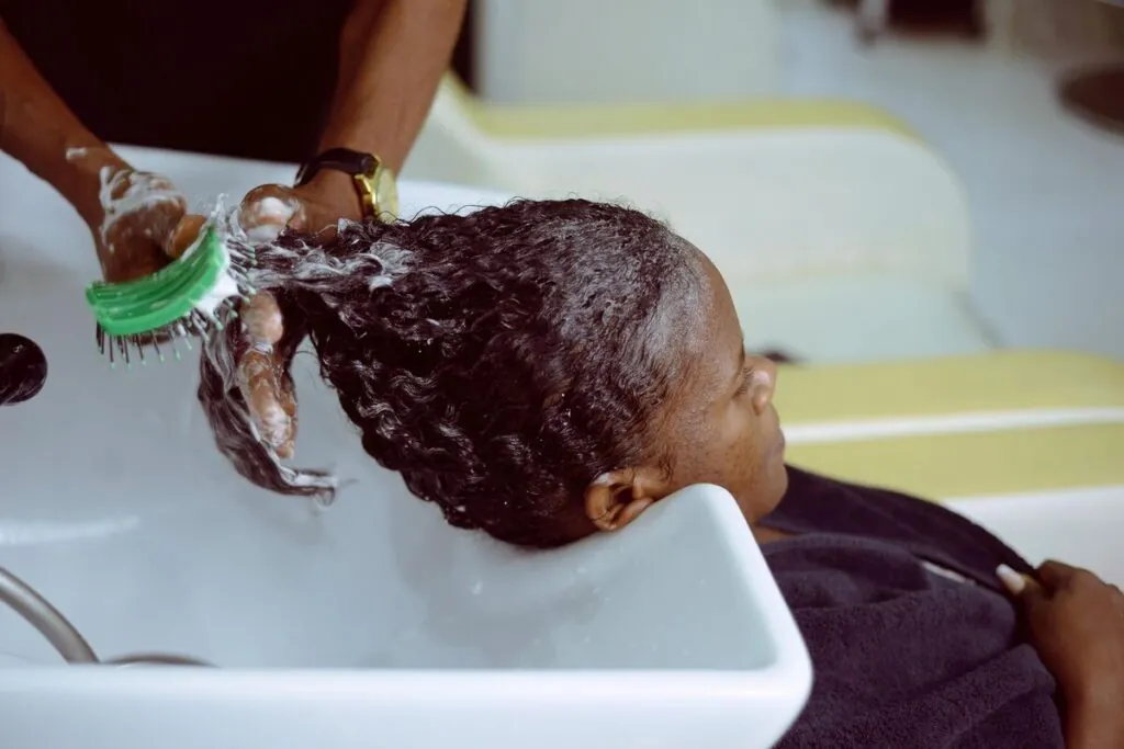 Curly hair being shampooed at a salon basin