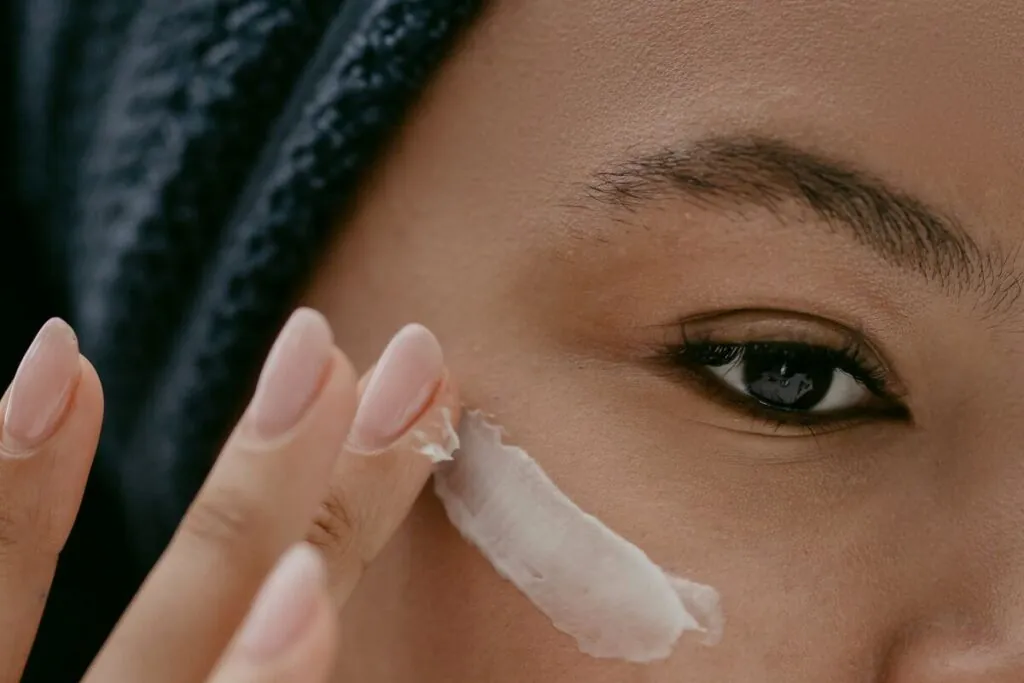 Woman applying moisturiser to her cheek