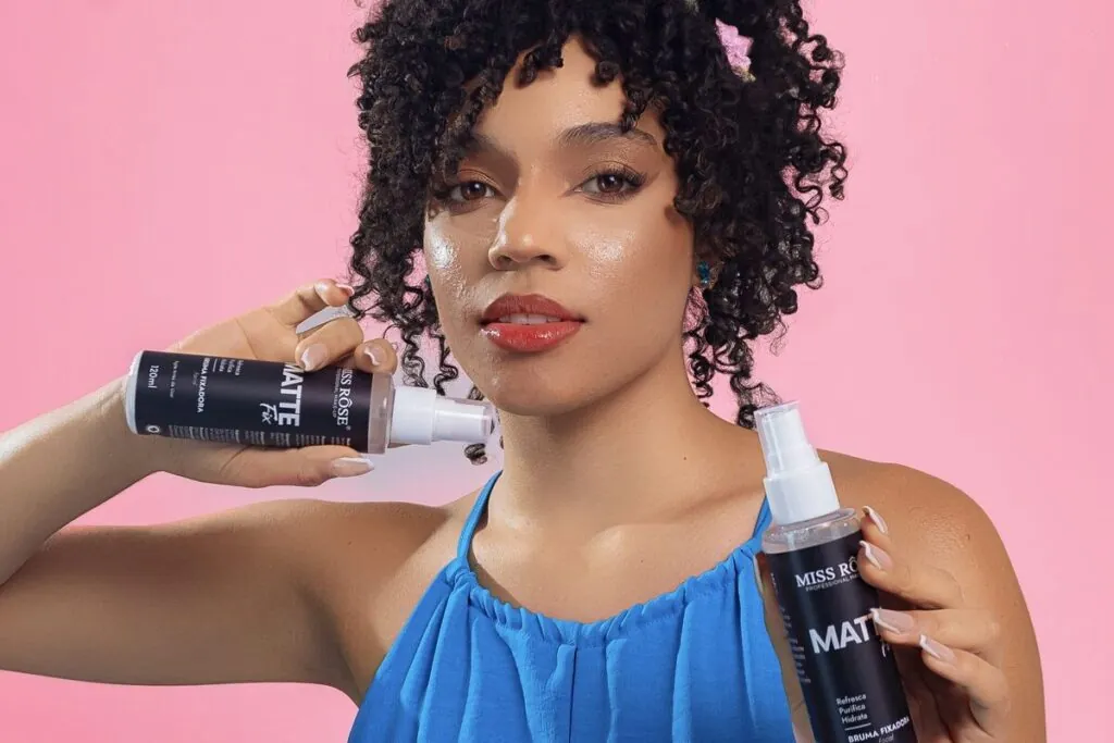 Woman with curly hair holding a hair styling product