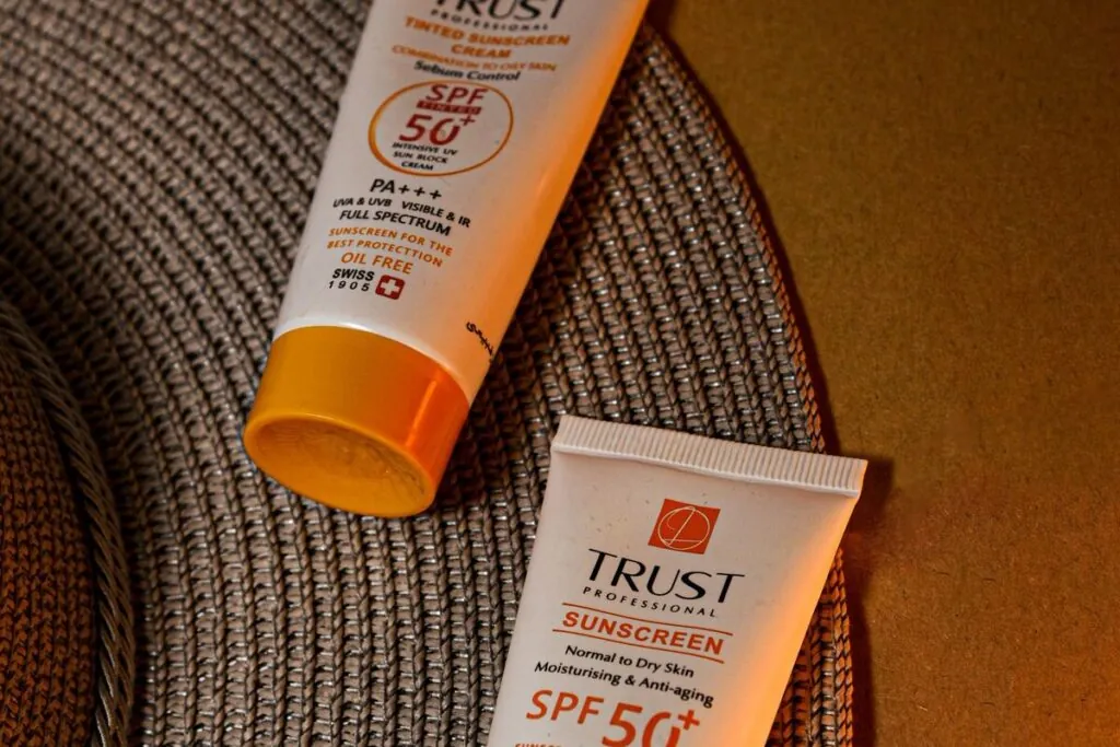 Two SPF 50 sunscreen tubes on a woven mat