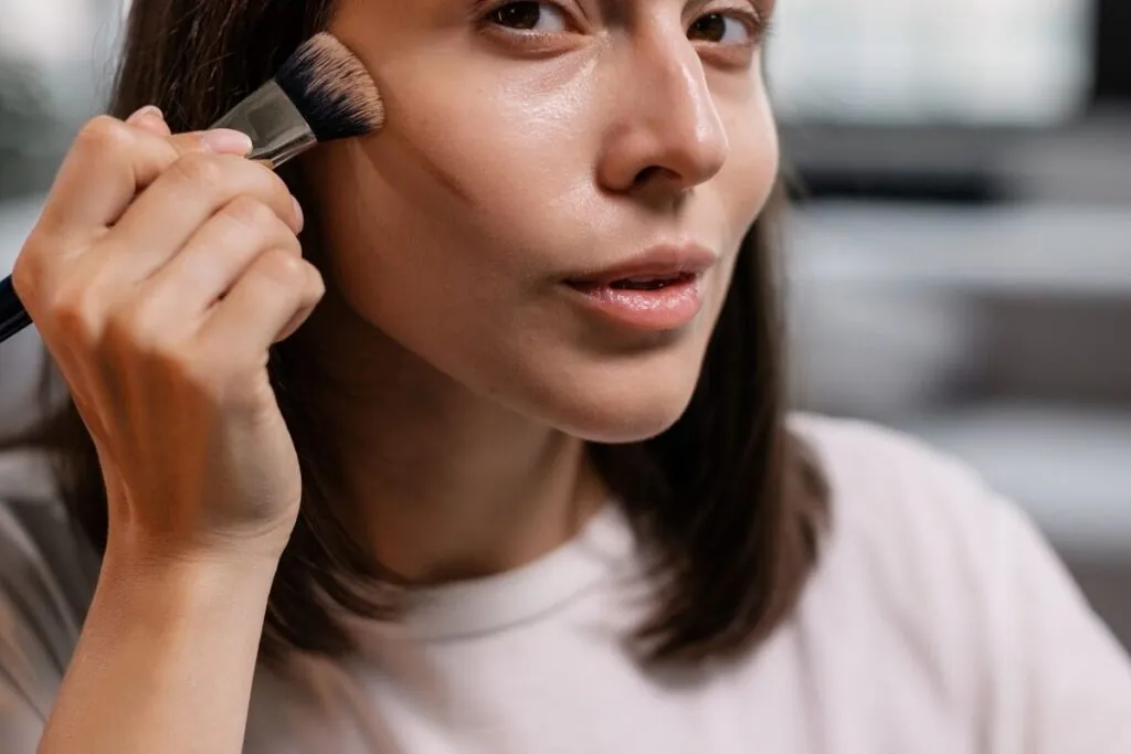 Woman blending foundation with a brush