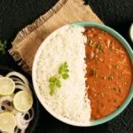Plate of dal and rice with green chutney and onion salad
