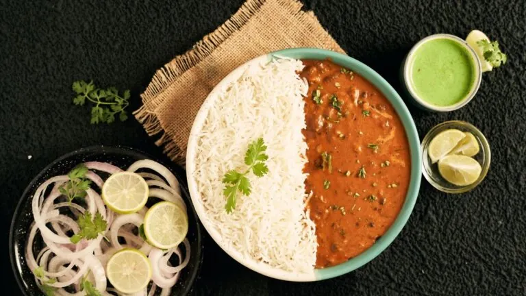 Plate of dal and rice with green chutney and onion salad