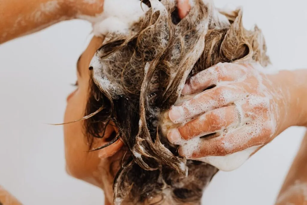 Woman lathering shampoo into her hair