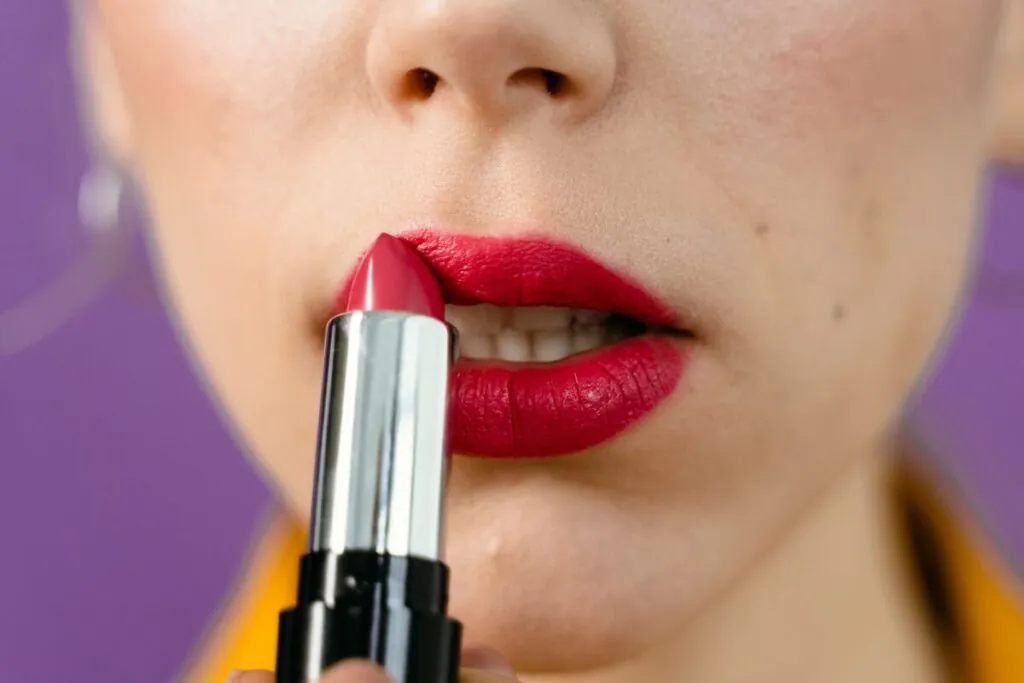 Red lipstick being applied to the lips
